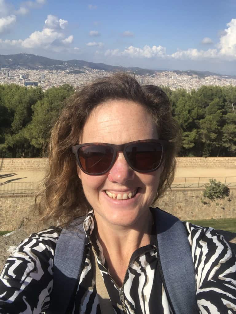 Selfie of Jude taken at Montjuic with views of Barcelona city and distant mountains in the background.