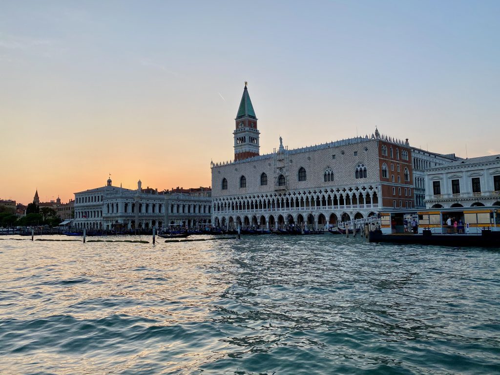 View of the Doges palace at sunset from a water bus on the Venetian lagoon.