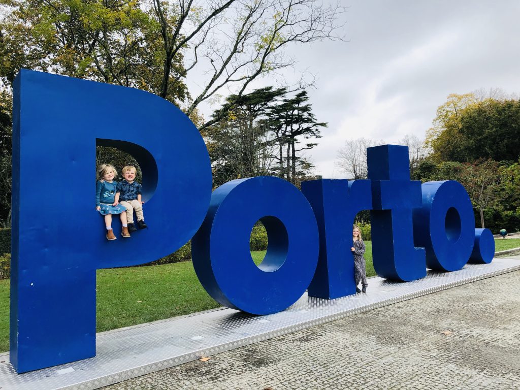 Children sat on Porto sign in Jardins do Palácio de Cristal.