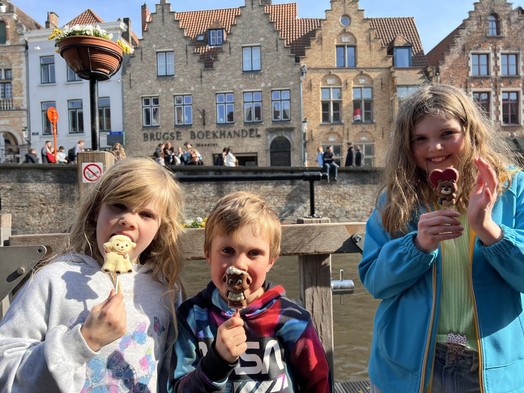 Children enjoying ice cream in front of the canal in Brugges, Belgium.