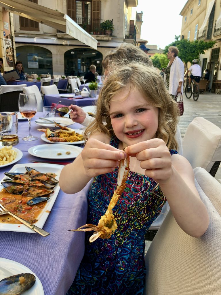 Chloe enjoying her seafood dinner in a restaurant in Alcudia.