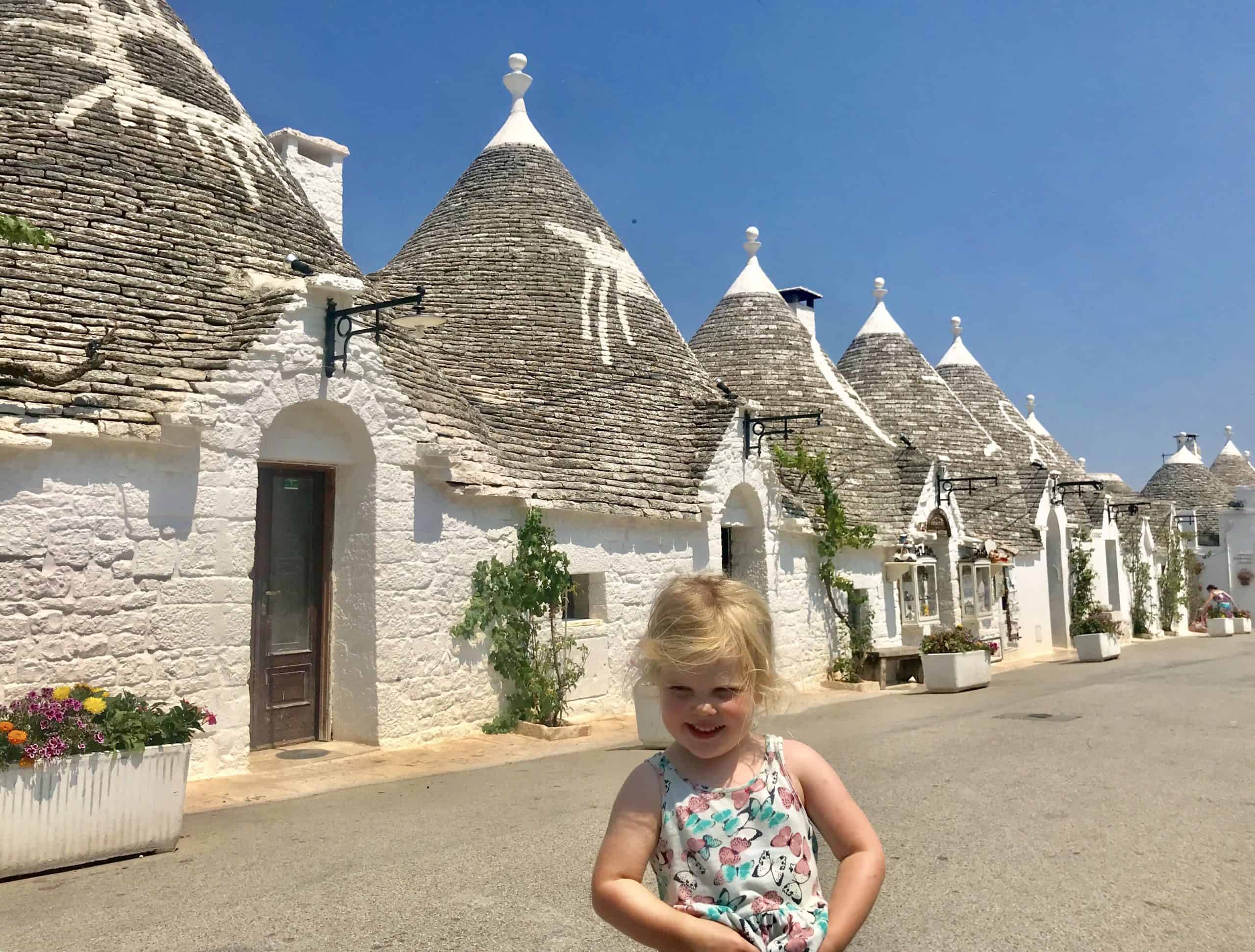 Martha outside the trulli houses in Alberobello, an essential place to visit on your itinerary for Puglia.
