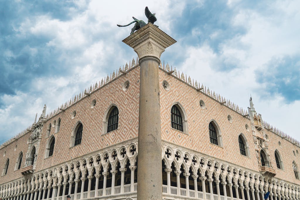 Architectural detail of Doge's Palace, Venice with clear sky backdrop.