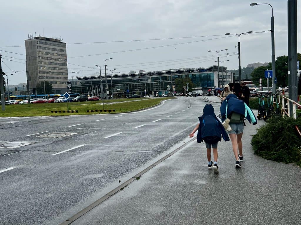 Two children walking with backpacks towards Kosice Train Starion