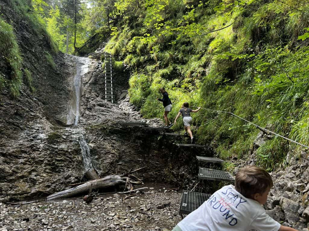 Children using the chains and ladders on the Sucha Bela trail in Slovak Paradise National Park. 