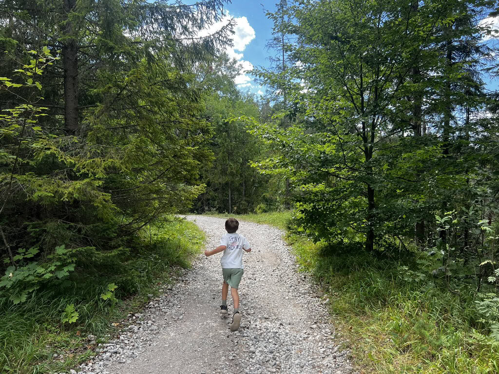 Benjamin running along the gravel trail which snakes back down the hill from the summit of the Sucha Bela trail to Podlesok.