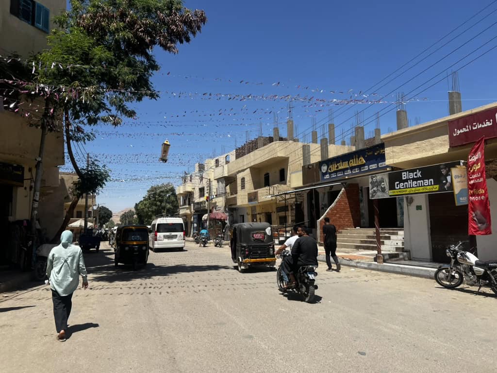 Local egyptian life including people walking, motorbikes and Tuk Tuks on Al Qarna Road in the West Bank of Luxor. 