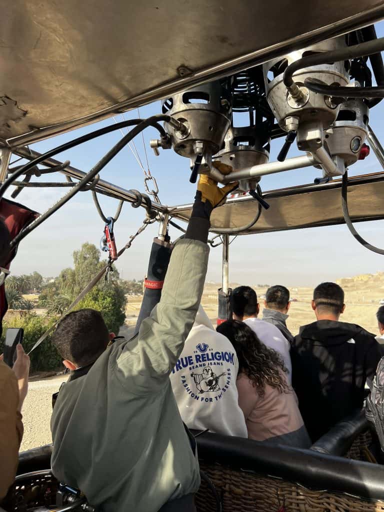 Hot air balloons pilot controlling the balloon for landing.
