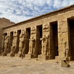 View of the interior of Habu Temple on the West Bank of Luxor, showing carved statues in front of columns.