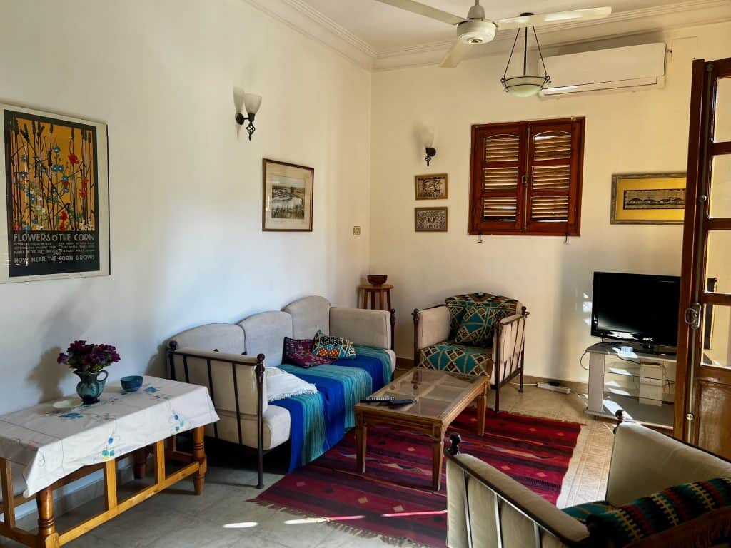 The living area of our apartment at Villa Belzoni in Luxor, featuring two armchairs, a sofa, coffee table and TV.