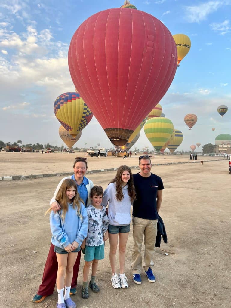 Our family in standing in front of hot air balloons in Luxor airfield.