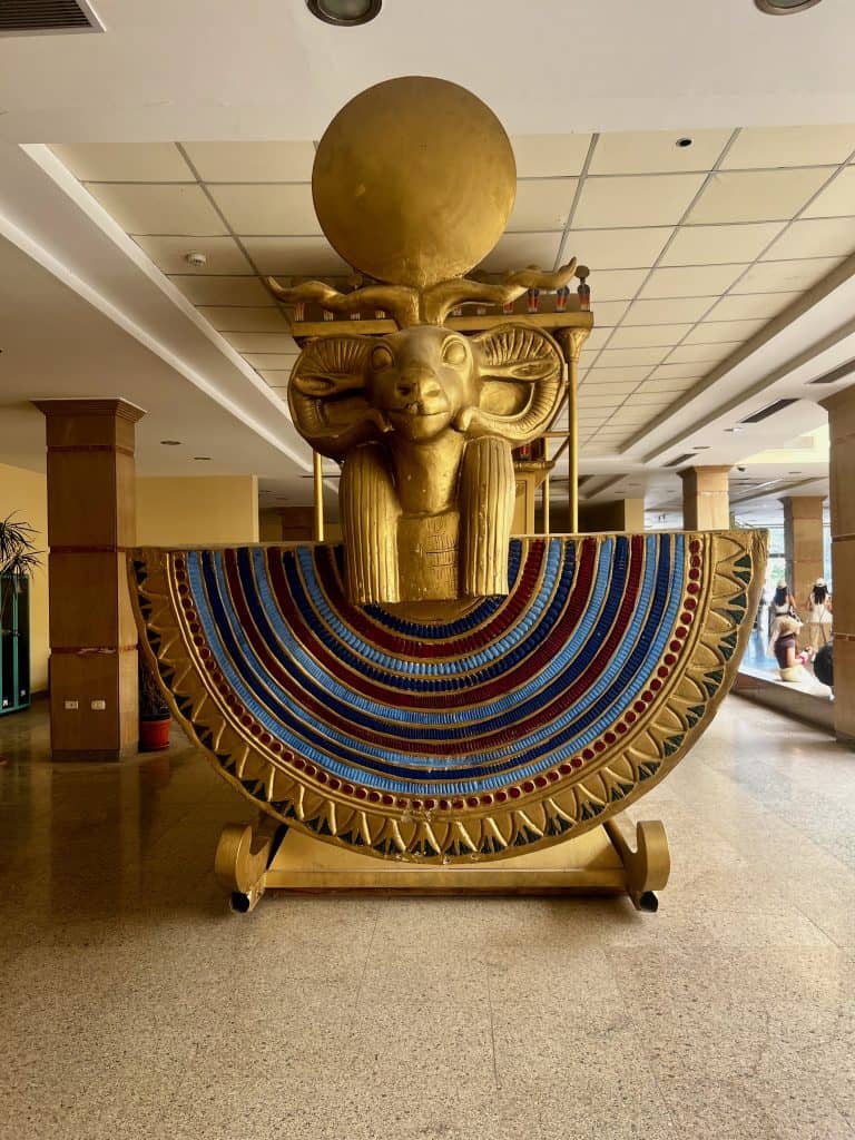 Front view of a replica sedan chair on display in the entrance hall of the Karnak temple complex in Luxor.