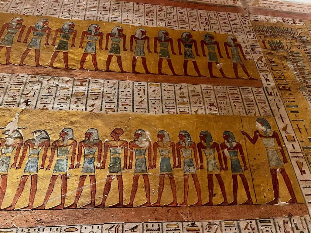 A view of the wall inside the tomb of Ramases IV (KV2) in Valley of the kings, Luxor. The vivid colours with yellow background show Egyptian art with hieroglyphics in between the pictures.