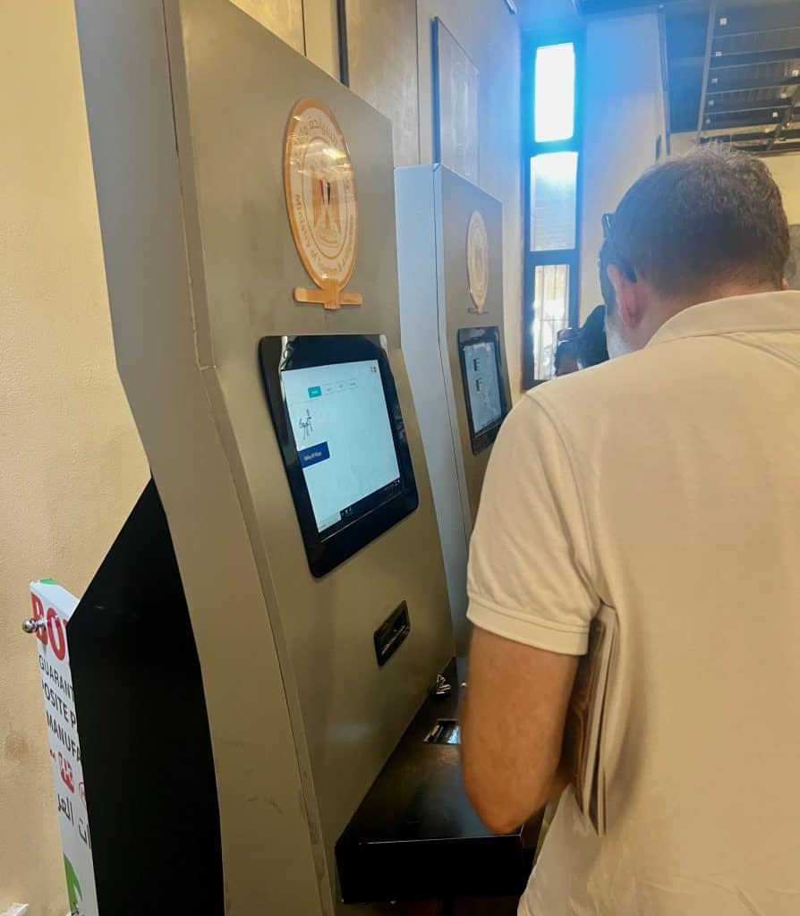 Man stood using the ticket machine to purchase tickets at the entrance to Valley of the Kings in Luxor, Egypt.