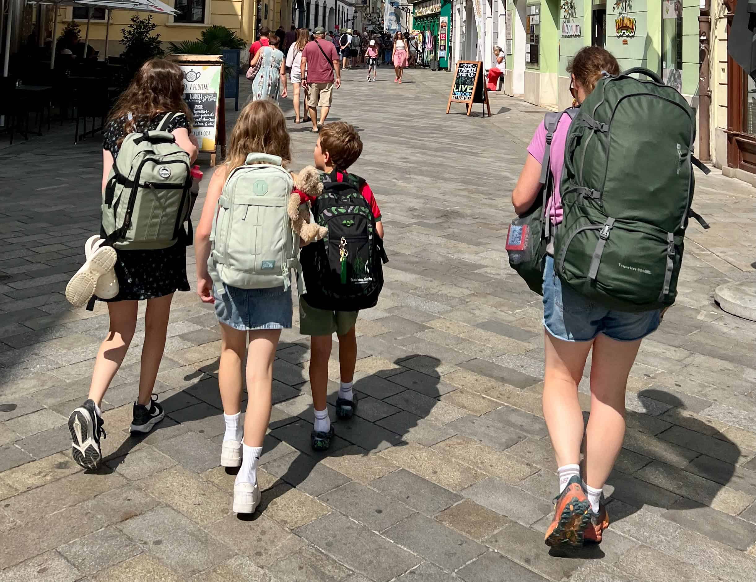Family walking through Bratislava carrying backpacks.